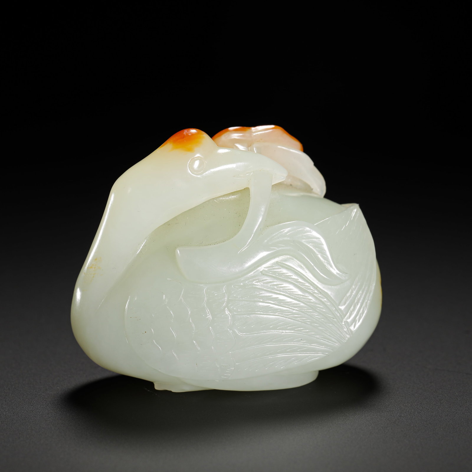 A RED-SKINNED, INGENIOUSLY CARVED GOOSE FROM HETIAN JADE OF THE QING DYNASTY: Height:5.3cm(2.09in) Width:6.2cm(2.44in) Weight:140g(0.31lb)Hetian top-grade white jade goose ornament with natural red russet skin, Qing Dynasty.Fine oily jade texture, natural concentrated red skin 