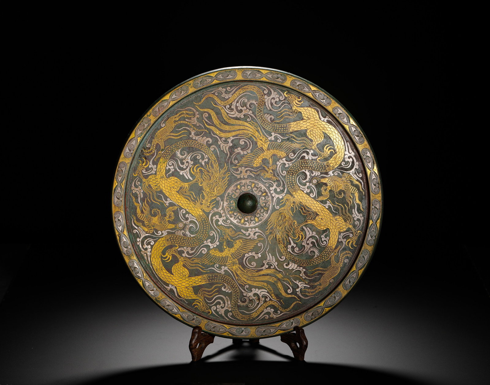 A ROUND BRONZE MIRROR WITH INLAID GOLD AND SILVER DRAGON AND PHOENIX PATTERNS FROM THE HAN DYNASTY (1 of 9)