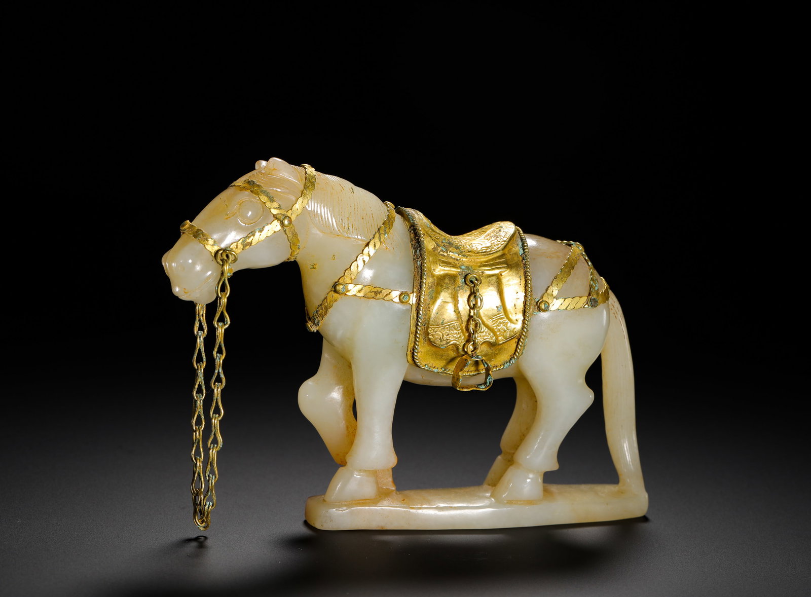 QING DYNASTY HETIAN WHITE JADE WRAPPED GOLD STANDING CHARIOT: Height:9cm(3.54in) Width:13cm(5.12in) Weight:280g(0.62lb)Qing Dynasty Hetian white jade standing horse statue inlaid with pure gold saddle and reins. Solid whole-jade carving with delicate mane and ta
