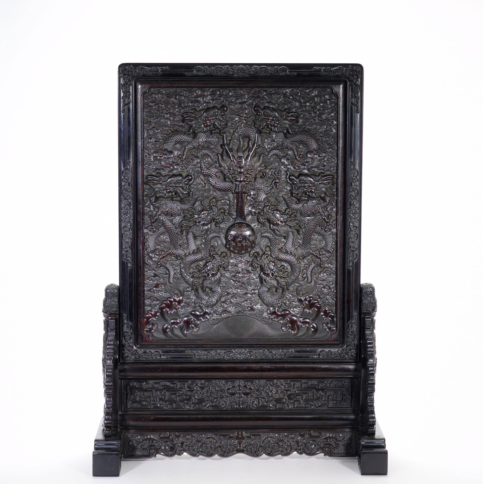 A large screen with a high relief of nine dragons playing with a pearl and an imperial inscription: Height:69cm(27.17in), Width:49cm(19.29in), Weight:6330g (13.955lb)Zitan Table Screen with Deep-Relief Nine Dragons Chasing Pearl and Poem InscriptionsThis imposing table screen is entirely carved from