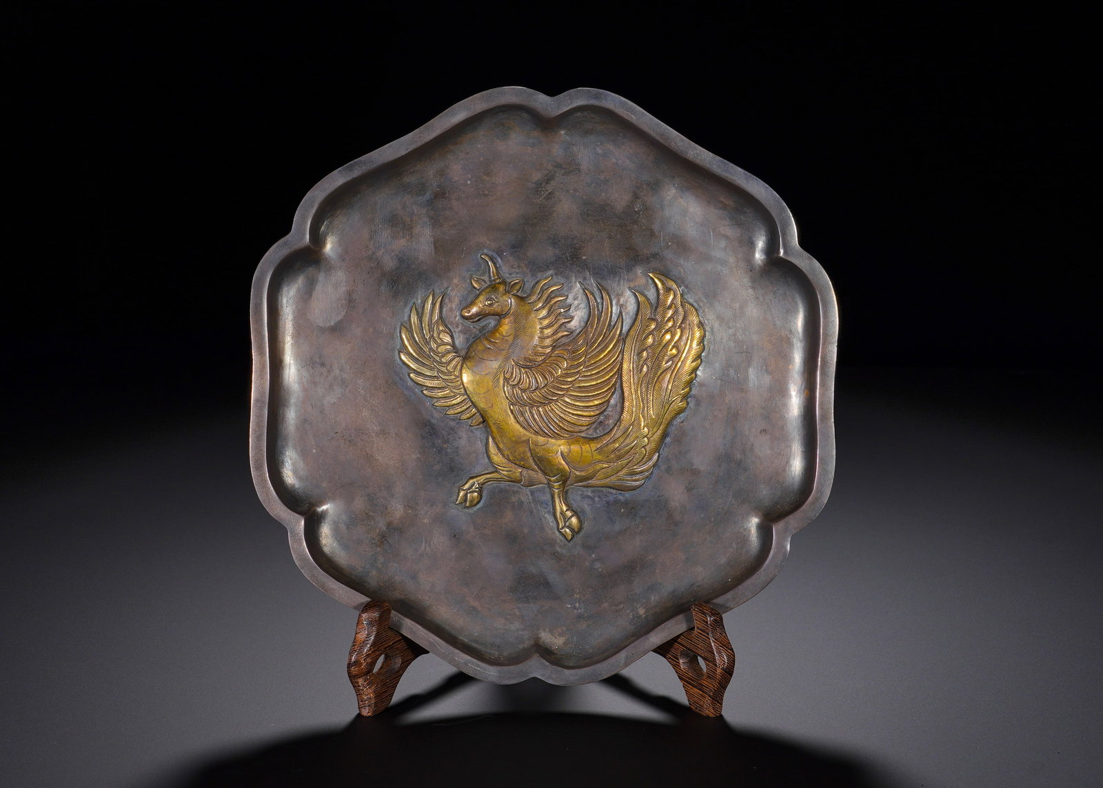 A silver gilt plate with a six-curved rhombus pattern in the Tang Dynasty: Height:2cm(0.79in), Diameter:19.8cm(7.80in), Weight:406g (0.895lb)Hammered from solid silver in octagonal foliate shape with graceful scalloped rim. The centre features high-relief winged mythical ste