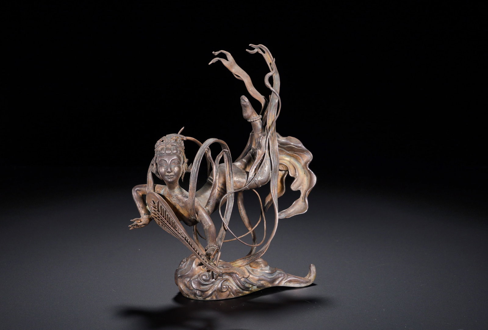 Silver flying apsaras of the Qing dynasty ?? ornaments: Height:14cm(5.51in), Width:12.5cm(4.92in), Weight:214g (0.472lb)Silver Statue of Apsara Playing Pipa Behind Her BackThis ornament is finely wrought in silver, modelled after the Dunhuang motif of the 