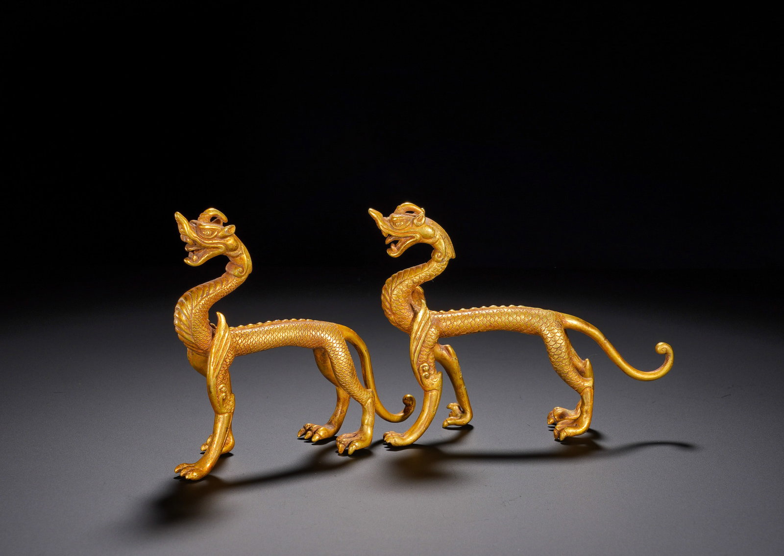 A pair of gilded bronze dragon pendants from the Han Dynasty: Height:11cm(4.33in), Width:15.5cm(6.10in), Weight:510g (1.124lb)Dragons embody supreme auspiciousness; a paired set symbolises double blessings, spiritual protection and thriving fortune. They may fun