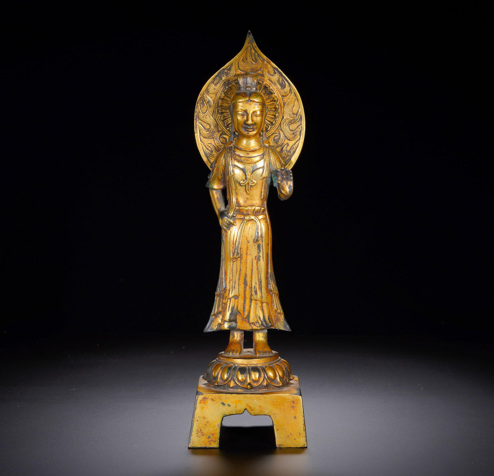 A gilded bronze statue of Guanyin Bodhisattva from the Northern Qi period: Height:33cm(13.00in), Width:10cm(3.94in), Weight:1280g (2.822lb)This gilt bronze standing Avalokiteshvara follows the early Chinese Buddhist sculptural tradition prevailing from Northern Dynasties to 