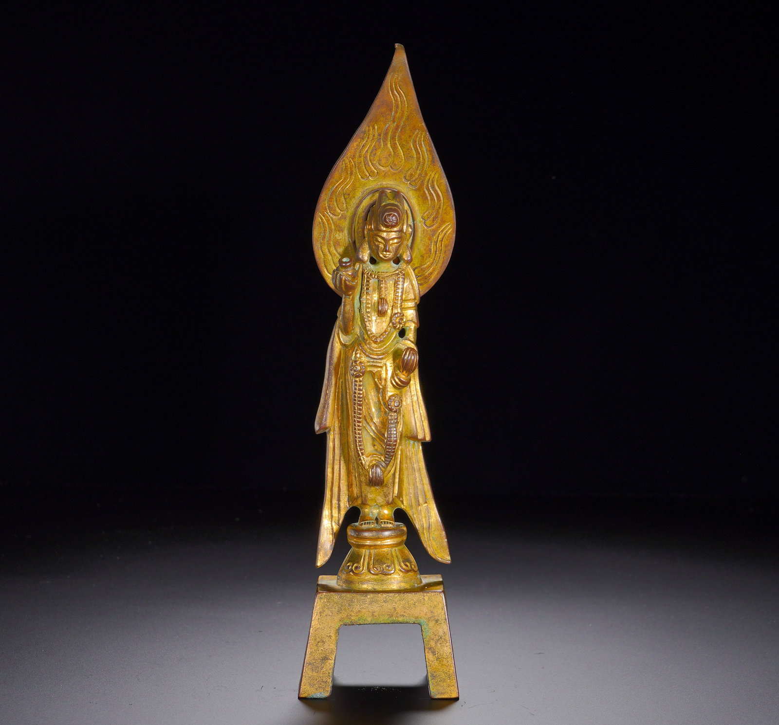 A gilded bronze statue of Guanyin Bodhisattva from the Northern Dynasties: Height:26cm(10.24in), Width:6.5cm(2.56in), Weight:620g (1.367lb)This gilt bronze standing Avalokiteshvara follows the classic Northern Dynasties “bench Buddha” format. The Bodhisattva stands o