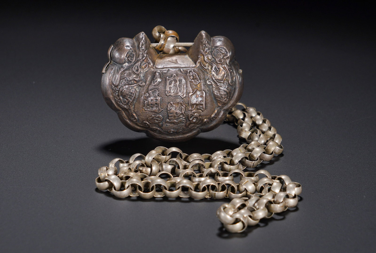 Silver double dragon longevity lock of the Qing Dynasty: Height:4cm(1.57in), Width:6.5cm(2.56in), Weight:90g (0.198lb)Silver Ruyi Lock Inscribed “All Roads Lead to Success” with Original Silver ChainShaped as a classic ingot-style longevity lock,