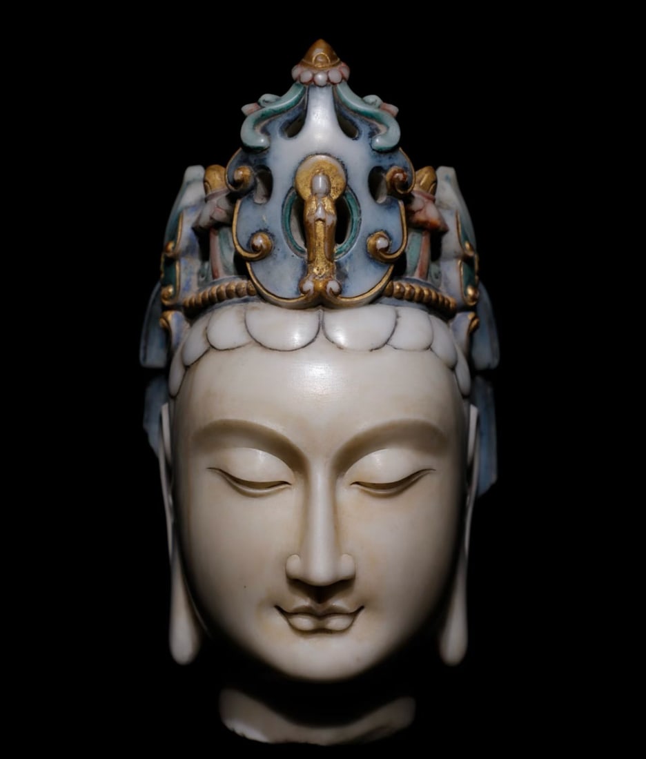 A white marble painted Guanyin head from the Northern Wei Dynasty: Height:36cm(14.17in)Polychrome and gilded white marble Avalokiteshvara head. Fine smooth marble material. Slender gentle facial features, lowered eyes embody tranquil compassion. An openwork crown