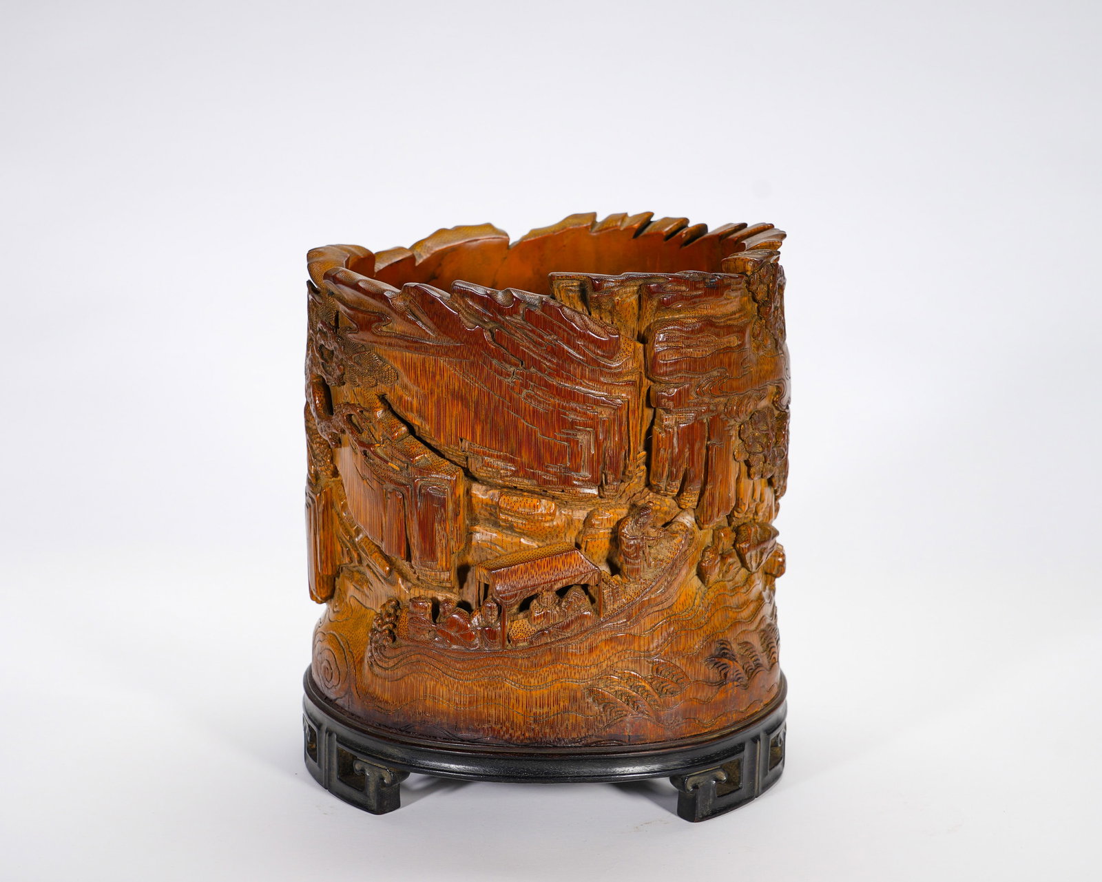 Qing Dynasty bam-carved pen holder of the elegant gathering in the deep mountains: Height:19cm(7.48in), Width:16cm(6.30in), Weight:30g (0.066lb)Deeply Carved Bamboo Brush Pot with Landscape and Figures (with Zitan Stand)Crafted from a single aged bamboo cylinder, the exterior is dec