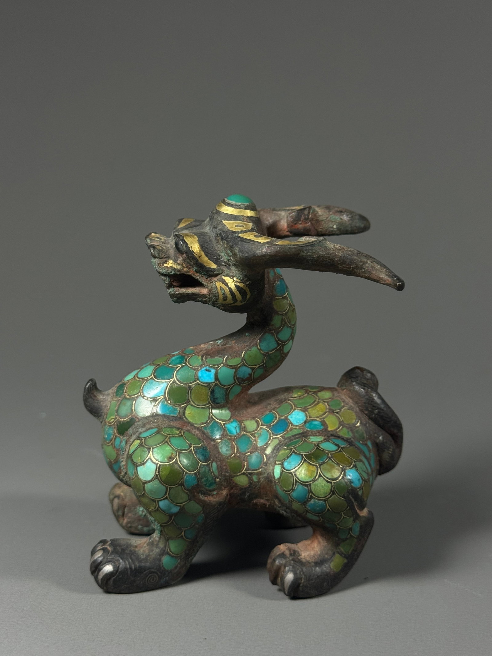 Gold inlaid with turquoise chilong town from the Warring States period: Height:8cm(3.15in), Width:7cm(2.76in)Warring States Bronze Chilong Weight Inlaid with Gold and TurquoiseBronze mythical chilong weight modelled in coiled posture. Fine gold inlay decorates dragon head