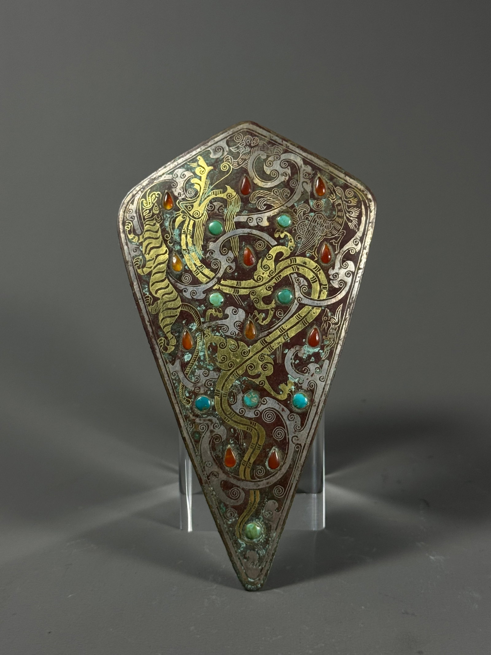 Warring States Inlaid gold and silver dragon, phoenix and tiger patterns inlaid gemstone copper: Height:14cm(5.51in), Width:8cm(3.15in), Weight:146g (0.322lb)Warring States Bronze Horse Frontlet, Gold & Silver Inlaid Dragon, Phoenix & Tiger Patterns Inlaid with GemstonesBronze shield-shaped fitti
