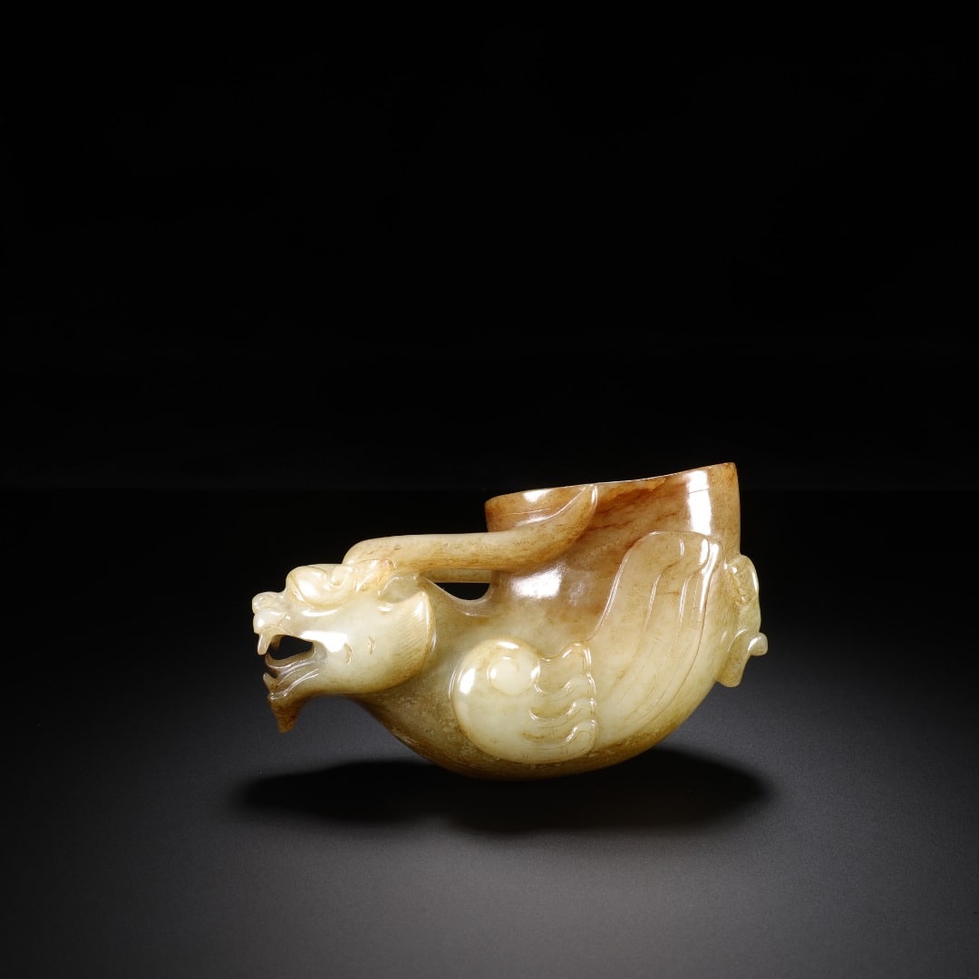 Han Dynasty Hetian jade beast-head cup: Long:9.8cm(3.86in), Width:4.3cm(1.69in), Height:5.3cm(2.09in), Weight:218g (0.481lb)Ancient jade beast-headed winged wine cup. Carved from bluish-white jade covered with natural amber patina. One end