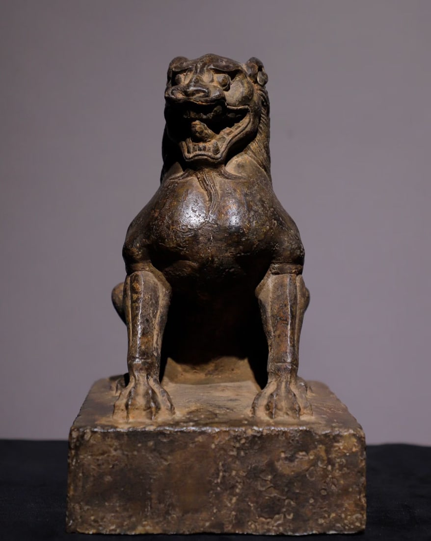 A Northern Wei Dynasty bluestone crouching lion statue: Height:26cm(10.24in), Long:20cm(7.87in), Width:16cm(6.30in)Carved bluestone seated lion, sculpted integrally with rectangular base. The lion crouches, head raised, mouth open in a powerful imposing