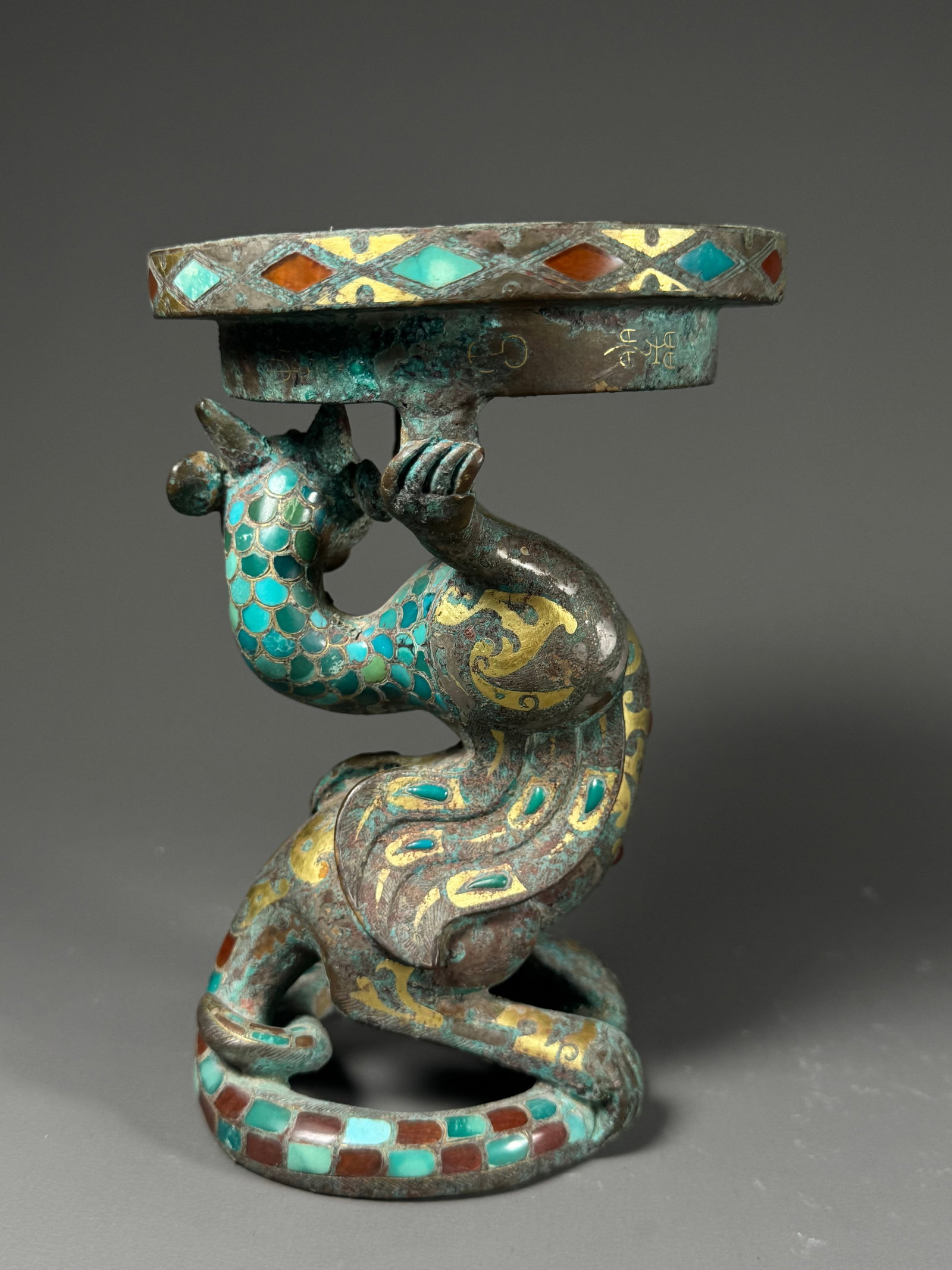 Bronze lantern with gold inlaid with turquoise and chilong: Height:15.5cm(6.10in), Width:10.5cm(4.13in), Weight:1092g (2.407lb)Warring States Bronze Lamp Supported by Chilong, Gold Inlaid and Turquoise InlaidThe lamp base is formed by a coiled chilong dragon.