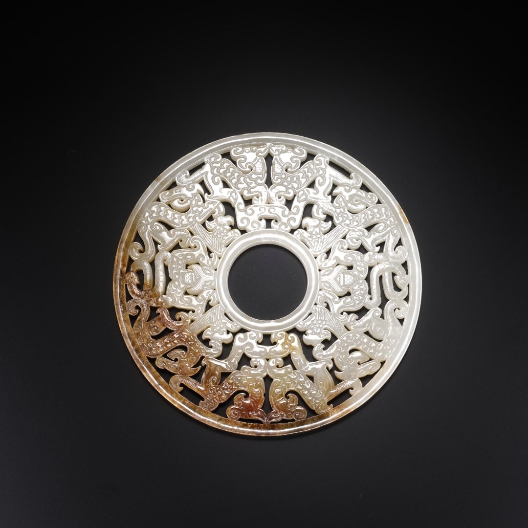 Han Hetian jade jade disc with hollowed-out dragon and phoenix patterns: Width:12.2cm(4.80in), Thick:0.5cm(0.20in), Weight:146g (0.322lb)Carved from Hetian white jade, with natural brown ancient patina spreading along the outer edge. Shaped as a circular jade bi, it adopts