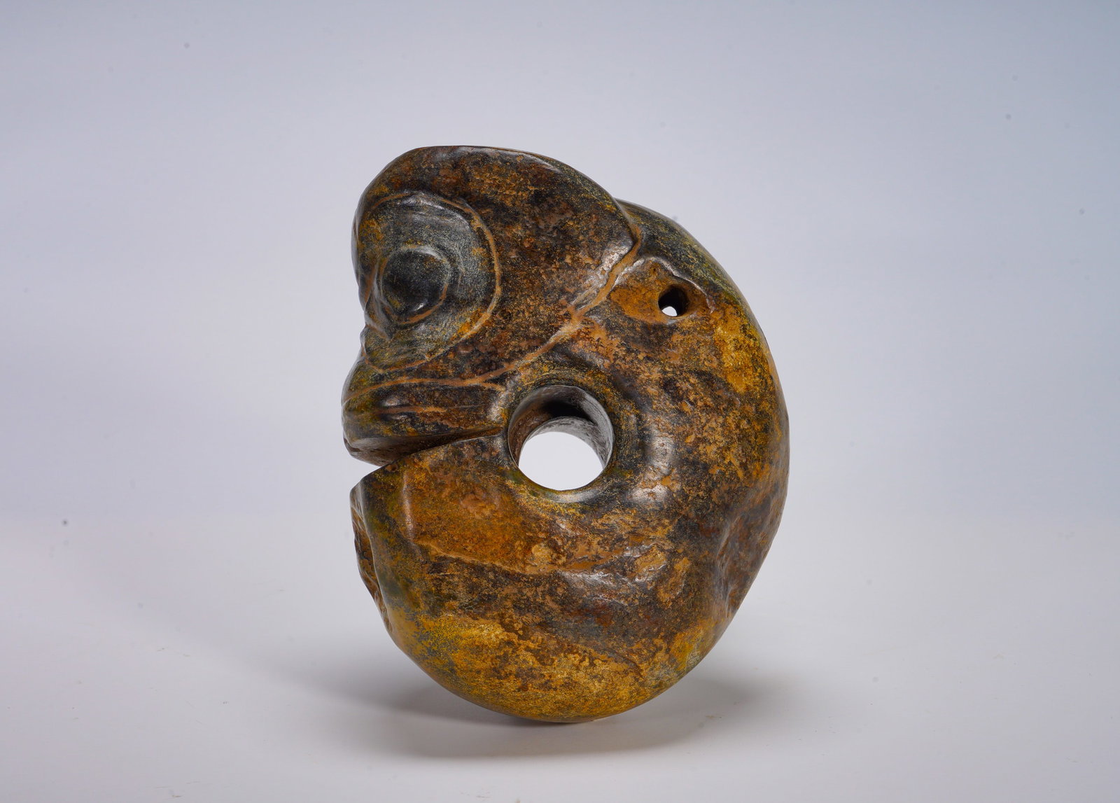 Red Mountain Culture Jade Pig Dragon Pendant: Height:17cm(6.69in) Width:13.5cm(5.31in) Weight:2380g(5.25lb)The iconic C-shaped jade ornament of Hongshan culture. It features rounded head with large circular eyes, snout stretching forward, curled