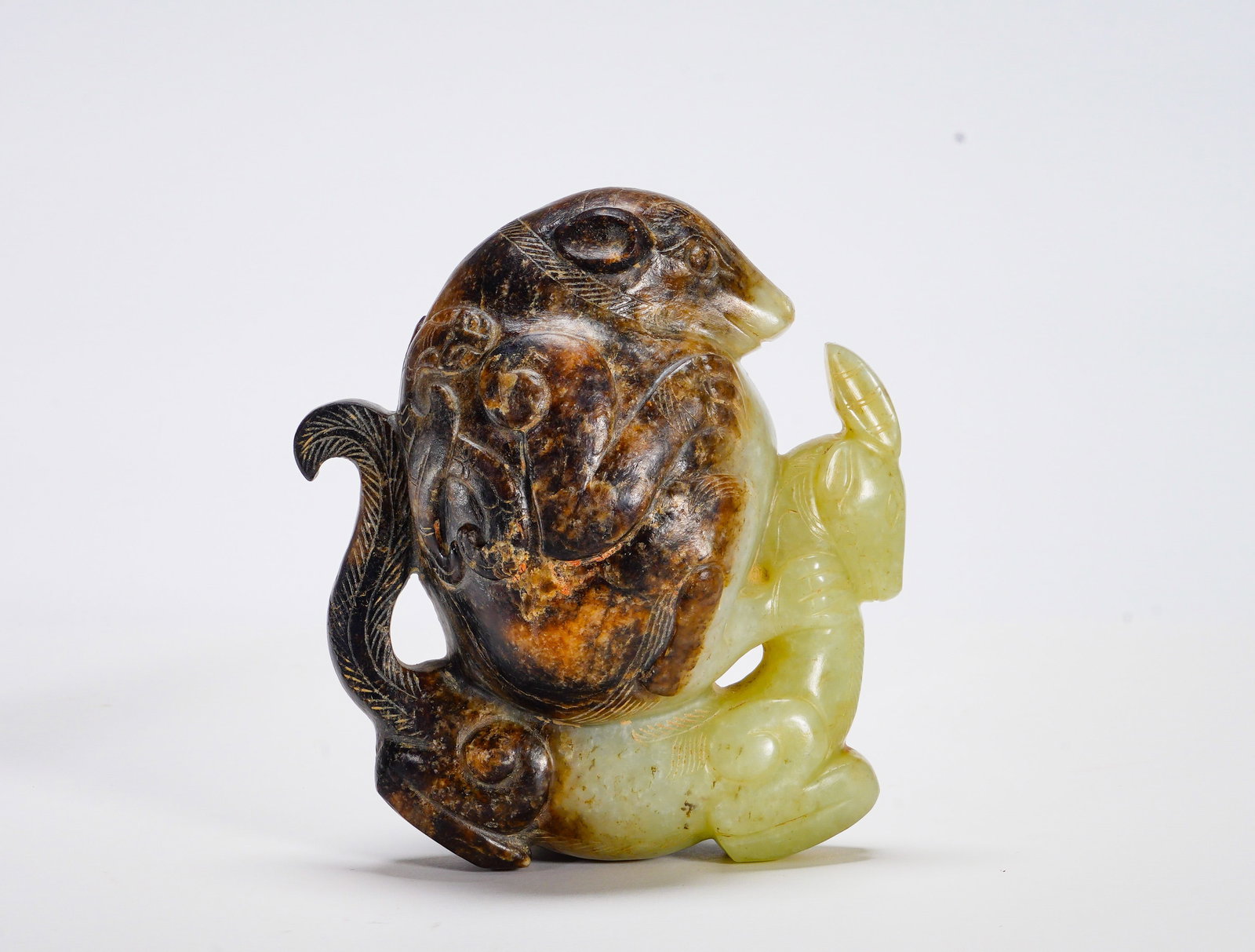 Han Dynasty Hetian jade auspicious beast carrying a sheep: Height:11cm(4.33in) Width:10cm(3.94in) Weight:670g(1.48lb)The integrated jade carving depicts curled sacred beast and recumbent ram. Pale yellowish jade with large natural russet patina. Ram
