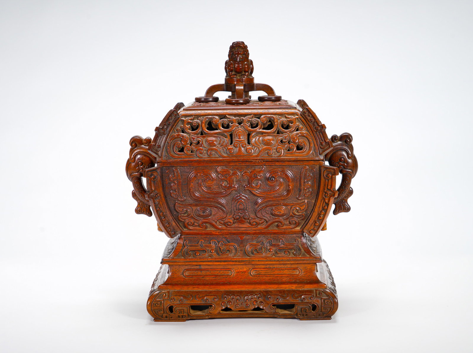 A four-sided incense burner made of huanghuali in the Qing Dynasty: Height:27cm(10.63in), Width:24cm(9.45in), Weight:1390g (3.064lb)Huanghuali Square Incense Burner with Lion Finial, Taotie Masks and Chi-Dragon HandlesCarved from solid huanghuali, this square censer