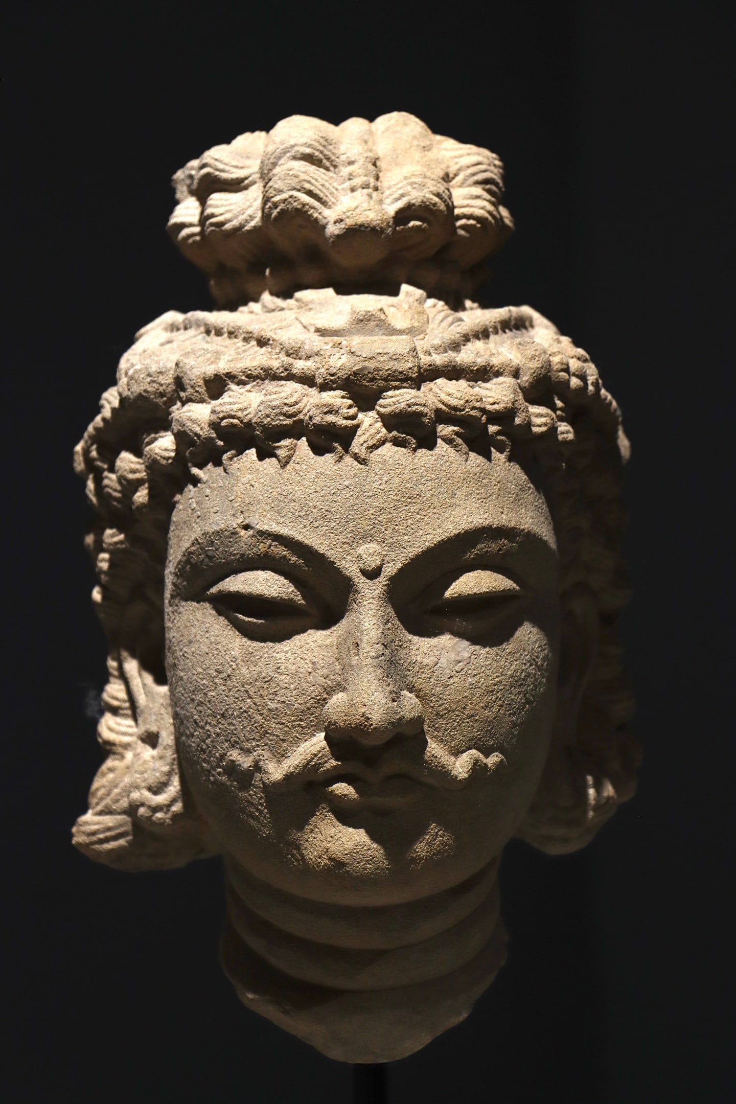 3rd century Gandhara-style sandstone Bodhisattva head: Height:54cm(21.26in), Height:33cm(12.99in)Sandstone Bodhisattva head of Gandhara style. The sculpture features elaborate wavy hair and high topknot, urna on forehead, half-closed eyes, moustache on