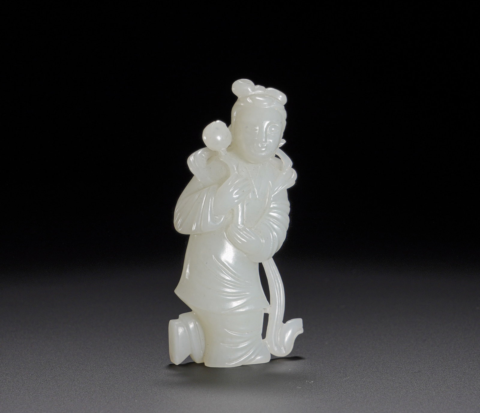 A standing figure of a lady holding a lotus in Hetian jade of the Qing Dynasty: Height:7.6cm(2.99in), Width:3.3cm(1.30in), Weight:50g (0.110lb)Hetian White Jade Carved Standing Lady Holding LotusCarved from a single piece of fine Hetian white jade with smooth, mild texture and