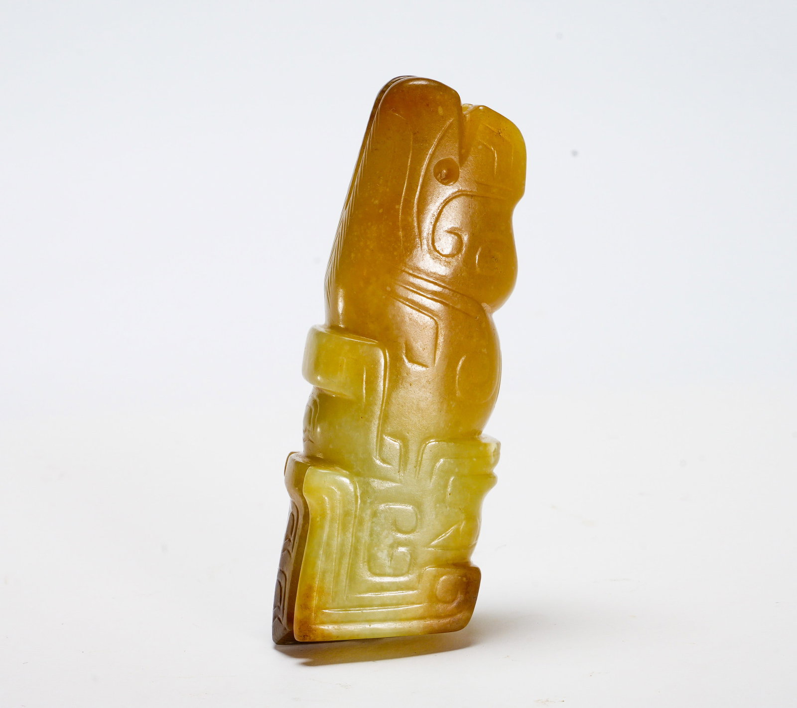 Shang Dynasty Hetian jade Divine Figure pendant: Height:9cm(3.54in) Width:3cm(1.18in) Weight:130g(0.29lb)The fully carved jade ornament of standing divine figure with tall crown, surface decorated with classic Shang spiral thunder patterns. Pale yel