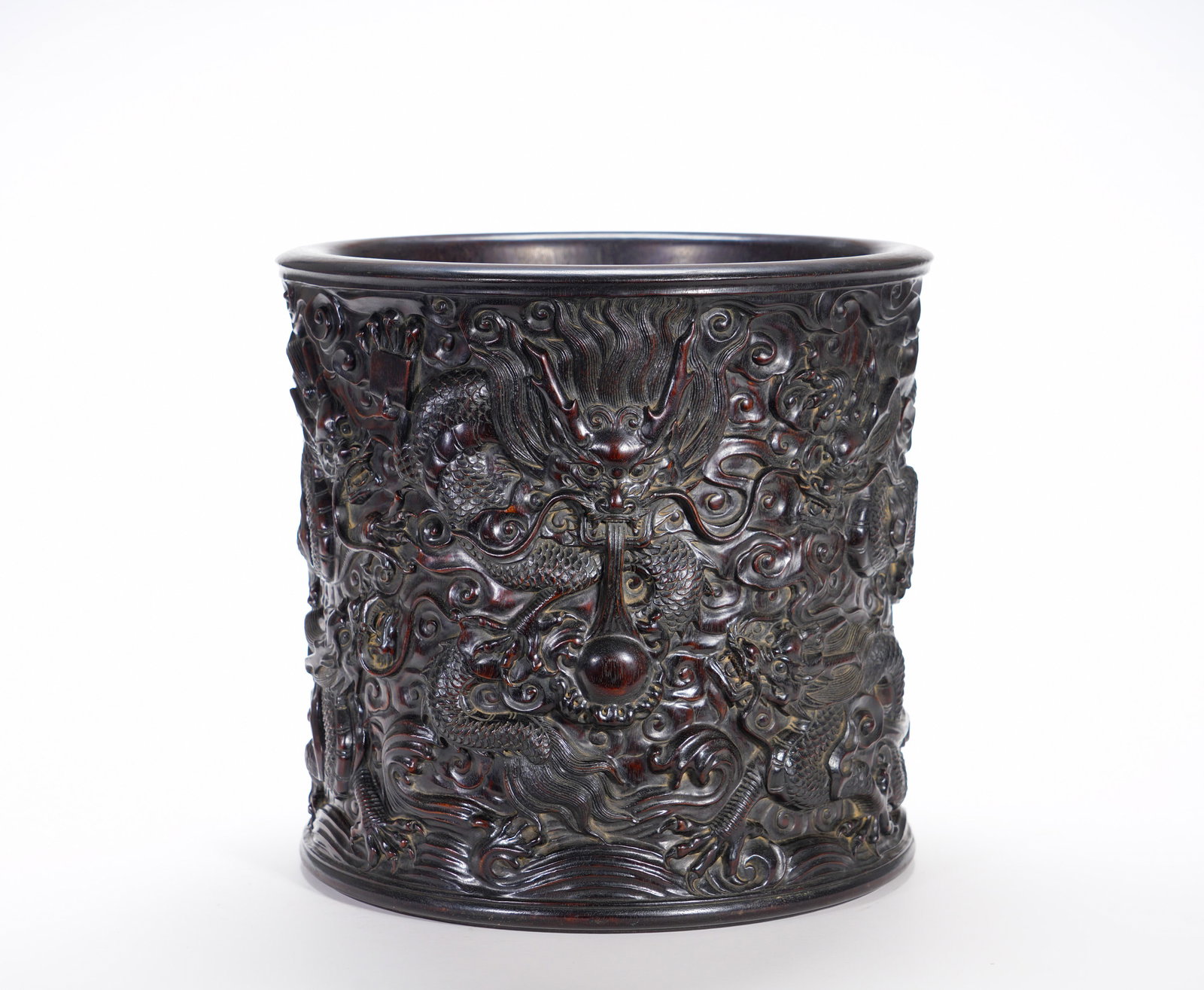 A high relief of nine dragons playing with a pearl pen holder made of rosewood from the Qing Dynasty: Height:26cm(10.24in), Diameter:28cm(11.02in), Weight:3760g (8.289lb)Large Zitan Brush Pot with High-Relief Carving of Dragons Chasing Pearl and Sea Wave MotifsHollowed integrally from a single block o