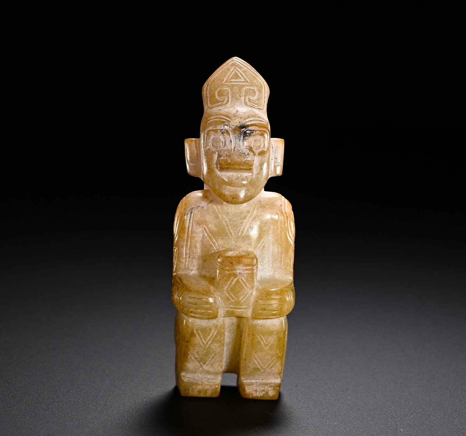 Han Dynasty Hetian jade Kneeling man: Height:9cm(3.54in)Width:3cm(1.18in)Weight:80g(0.18lb)Han Dynasty Hetian jade kneeling figure pendant. The figure wears a pointed crown decorated with triangular and cloud scroll patterns, with wide ey