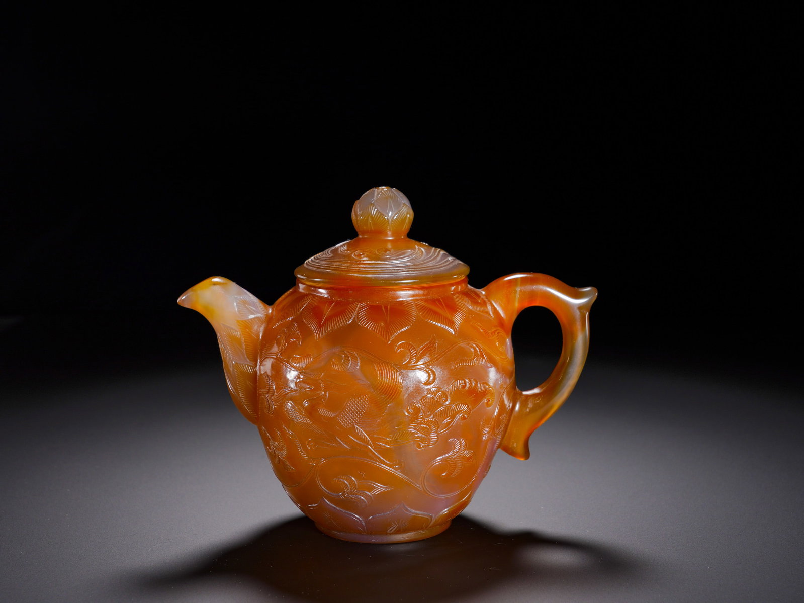 Tang Dynasty agate relief flower-and-bird patterned covered pot: Height:13cm(5.12in), Width:16cm(6.30in), Weight:510g (1.124lb)Agate Lidded Teapot with Relief Flower and Bird OrnamentationHollowed from a single block of natural orange-red agate, translucent and glo