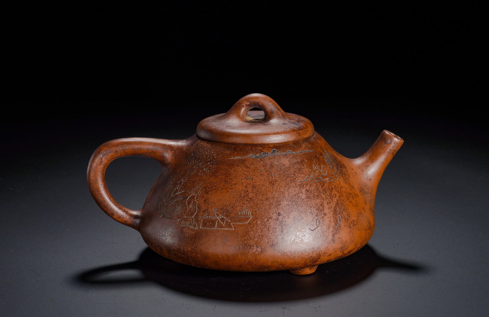 Zhu Ni Engraved Landscape Ziye Shipiao Purple Clay Teapot: Height:9cm(3.54in), Width:17.5cm(6.89in), Weight:420g (0.926lb)A landscape scene with distant hills, pavilions, trees and a solitary boat is finely engraved onto the surface, conveying serene literati
