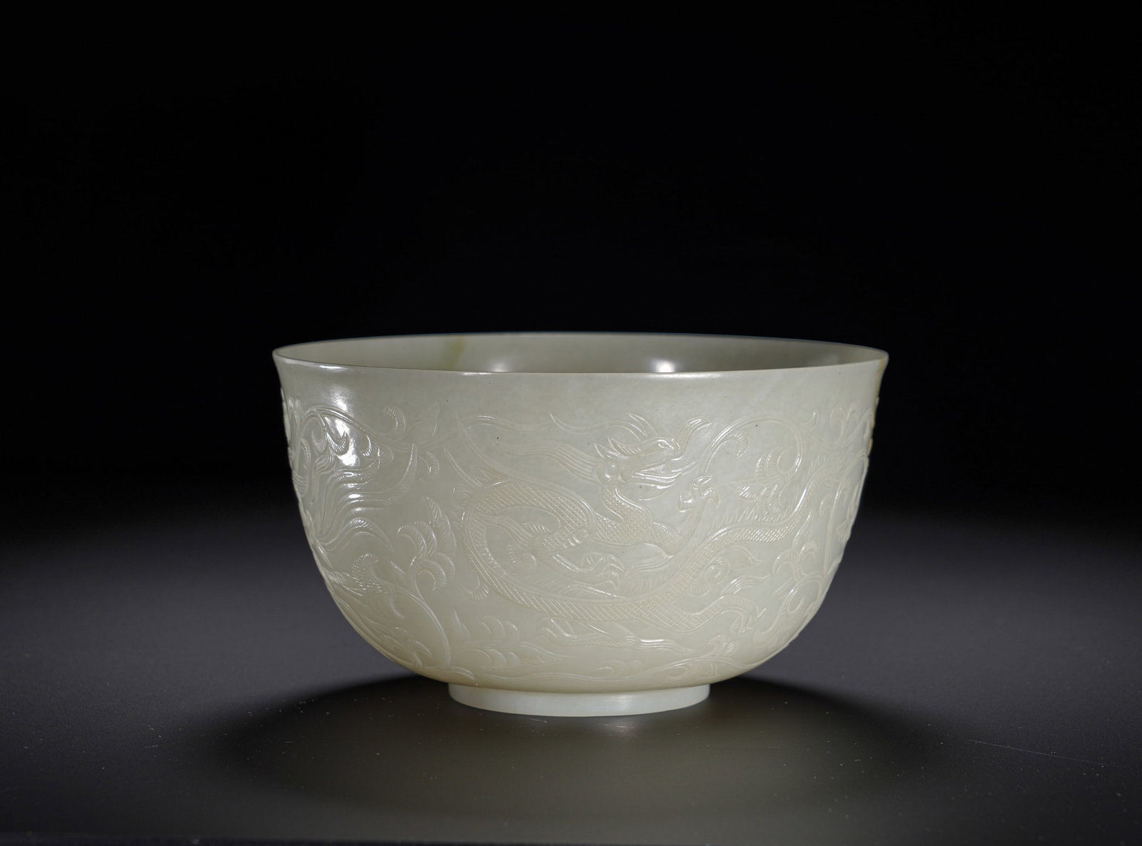 Tang Dynasty Hetian white jade dragon and phoenix wearing patterned jade bowl: Height:7.5cm(2.95in), Diameter:13.5cm(5.31in), Weight:180g (0.397lb)Hetian Pale Celadon Jade Bowl with Relief Dragon and Phoenix amid Floral ScrollsHollowed integrally from fine Hetian pale celadon ja