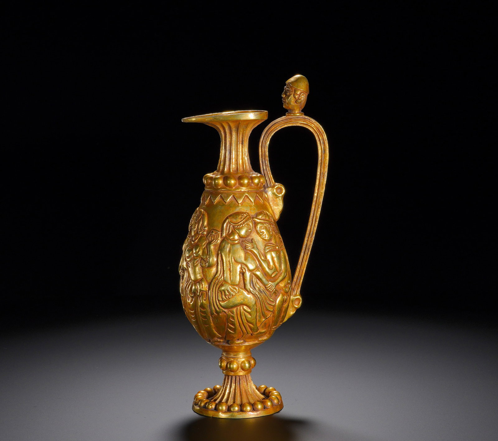 Tang Dynasty bronze gilded Western Regions pattern Hu-style ewer: Height:25cm(9.84in), Width:11cm(4.33in), Weight:450g (0.992lb)Gilt Bronze Ewer with Western Regions Figural Relief and Barbarian Handle FinialThe ewer features distinctive Western Regions stylistic tr