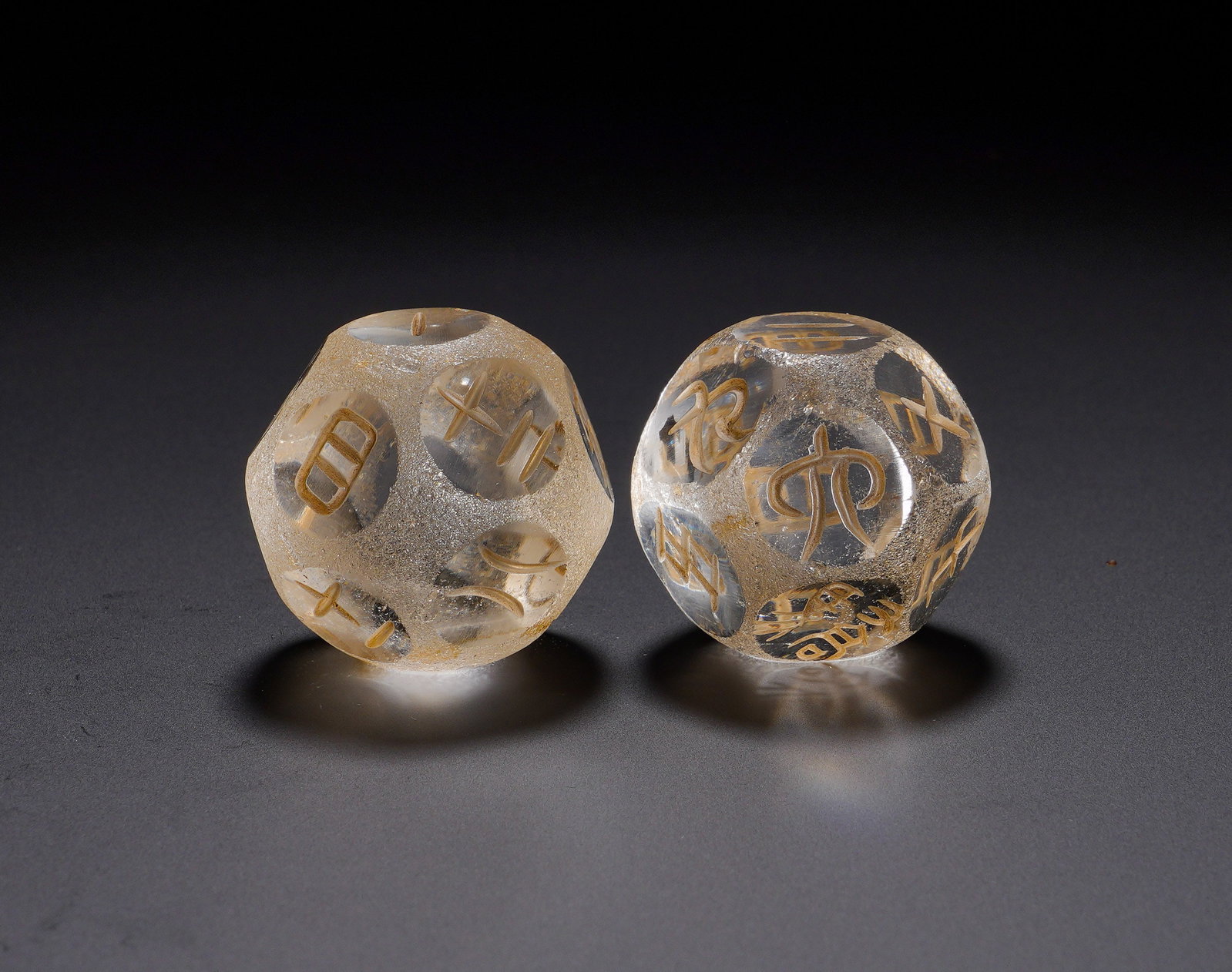 Han Dynasty crystal intaglio Boqiong: Diameter:2.9cm(1.14in) Weight:80g(0.18lb)Multi-faceted dice carved from natural crystal. Archaic seal script is incised and filled with gold pigment, with ancient weathered patina on surface. Boqiong 