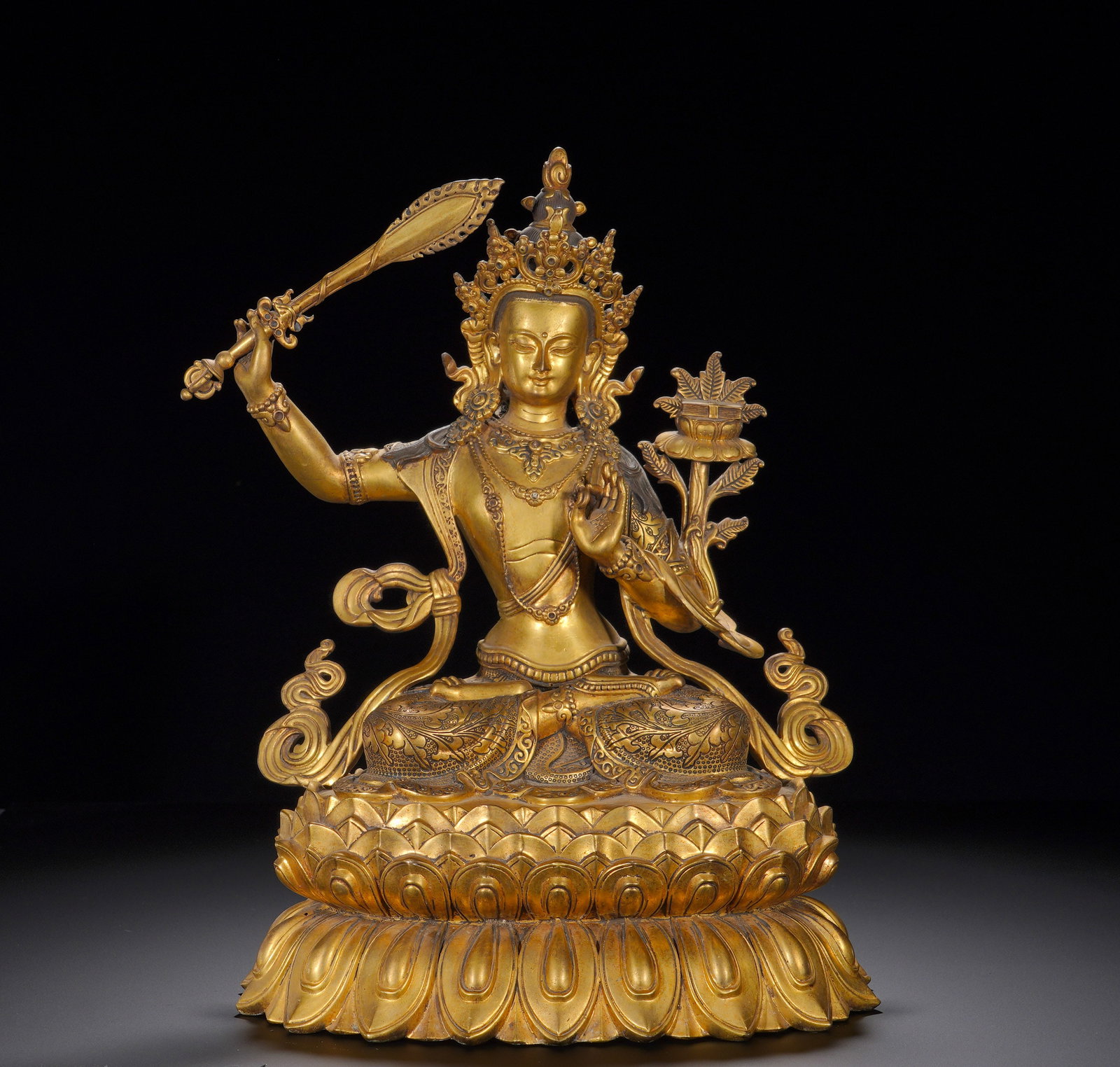 Gilded bronze Manjusri Bodhisattva statues from the Qing Dynasty: Height:34cm(13.39in), Width:25cm(9.84in), Weight:6700g (14.771lb)Manjushri wears an ornate crown, with a serene rounded face and half-closed eyes embodying wisdom and compassion. The figure is decorat