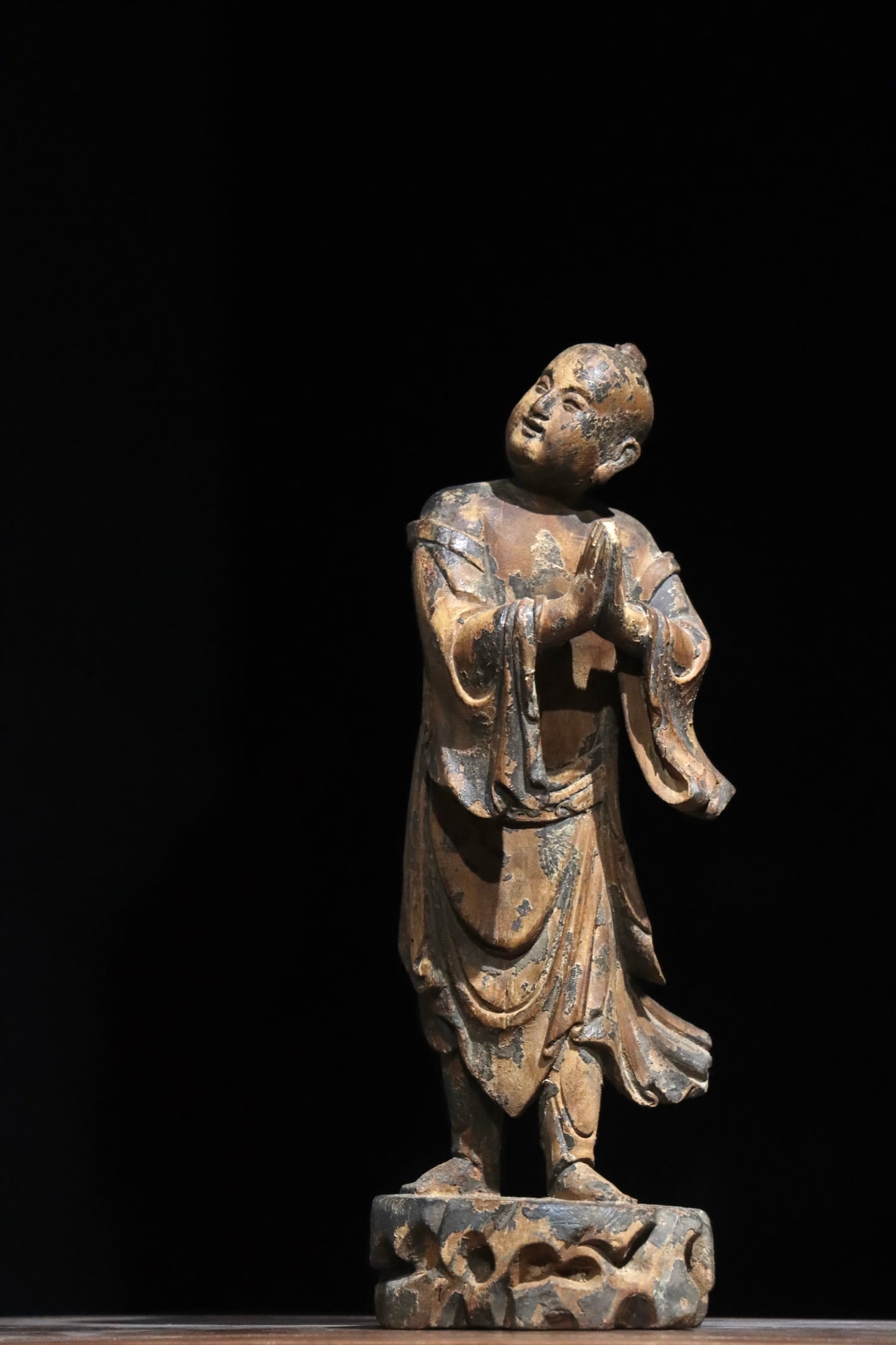A wooden boy of good fortune from the Song Dynasty: Height:35cm (13.78in)Wooden standing statue of worshipping boy, hands folded in prayer, wide-sleeved robe with flowing hem, hollowed rock-shaped base, traditional Chinese wooden Buddhist sculpture