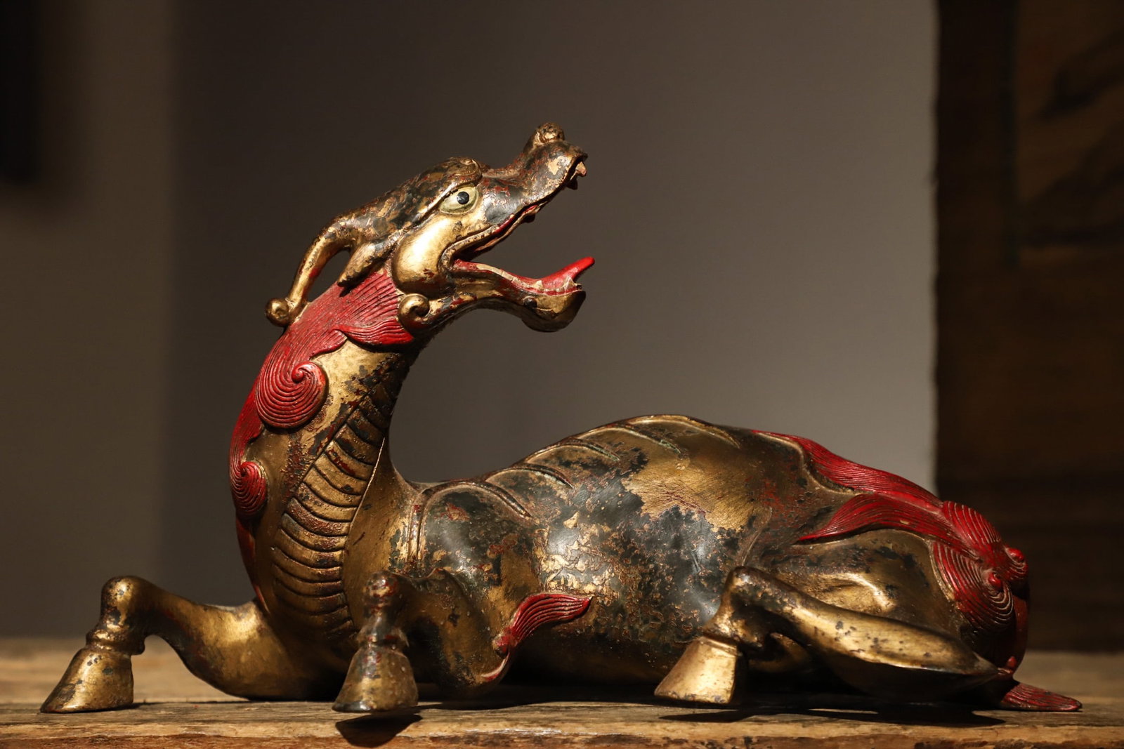 A reclining bronze gilded vermilion statue of a auspicious beast: Height:20cm(7.87in), Long:34cm(13.39in), Width:18cm(7.09in), Weight:3600g (7.937lb)This gilt bronze reclining auspicious beast with vermilion decoration dates to the Ming Dynasty. Crafted in gilt bron