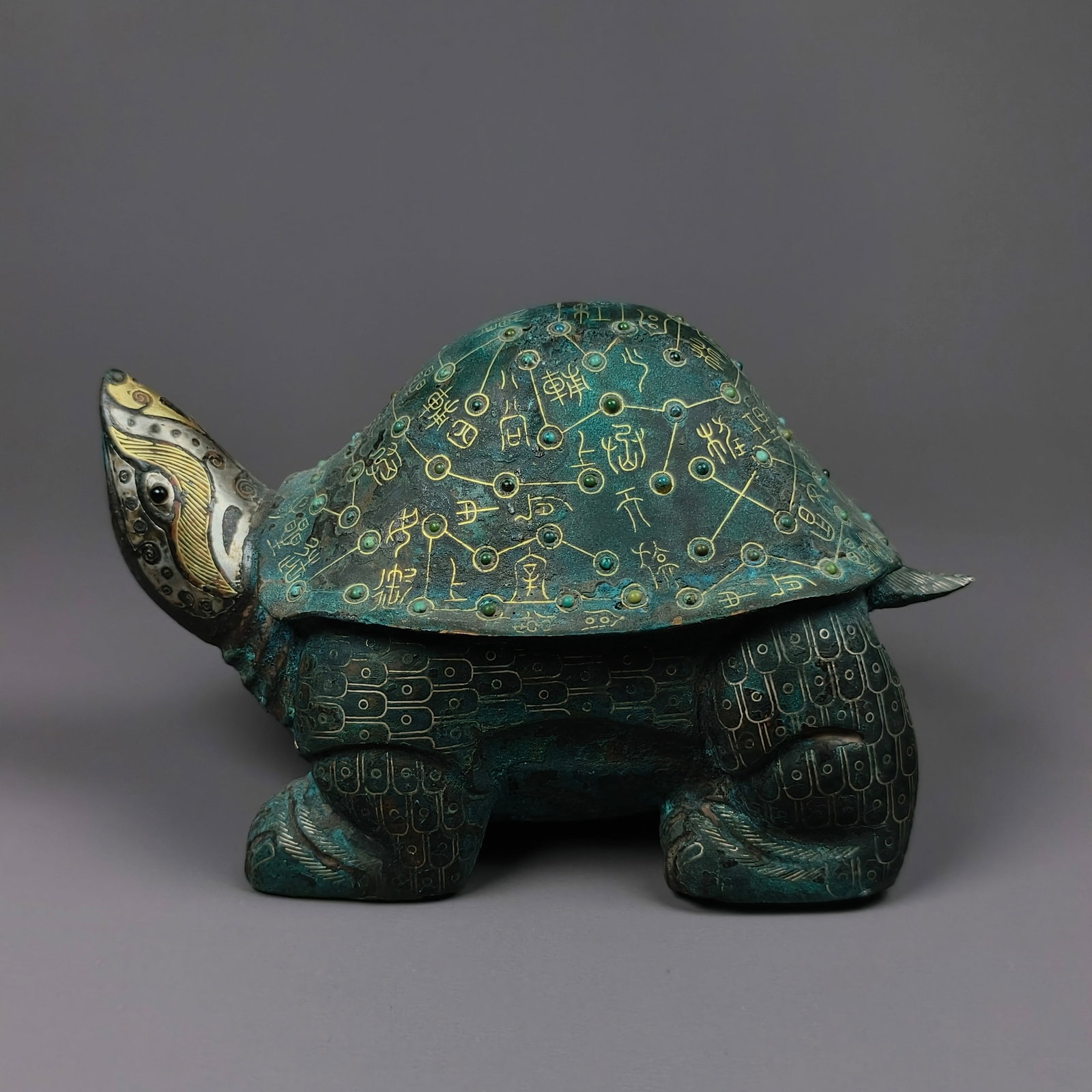Han Dynasty copper turtle with inlaid gold and silver inlaid turquoise astrological inscriptions: Height:9cm(3.54in), Width:14cm(5.51in), Weight:724g (1.596lb)Han Dynasty Bronze Tortoise with Gold & Silver Inlaid Star Map and Turquoise InlayBronze divine tortoise with gold-silver cloud scrolls on 