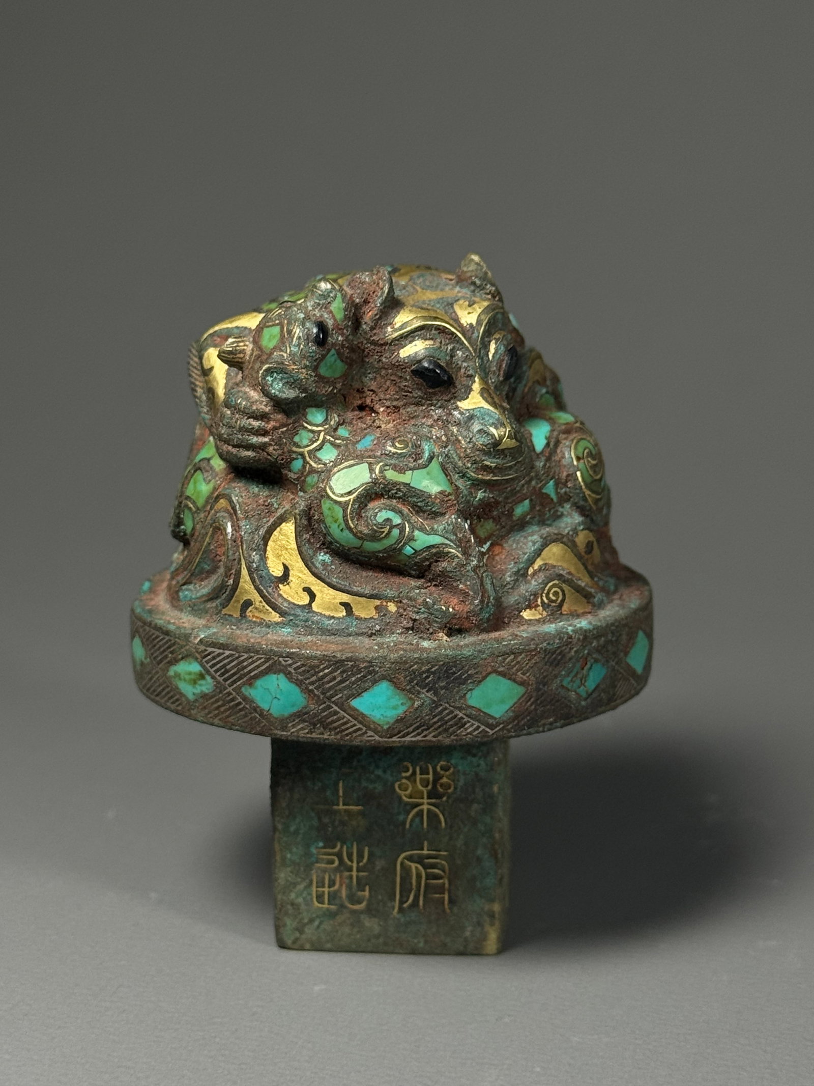 Han inlaid gold inlaid pine stone mother Bear Bronze town: Height:7.5cm(2.95in), Width:5cm(1.97in), Weight:241g (0.531lb)Han Dynasty Bronze Paper Weight with Mother & Bear Cub, Gold Inlaid & Turquoise InlaidThe top is sculpted as curled mother bear holding