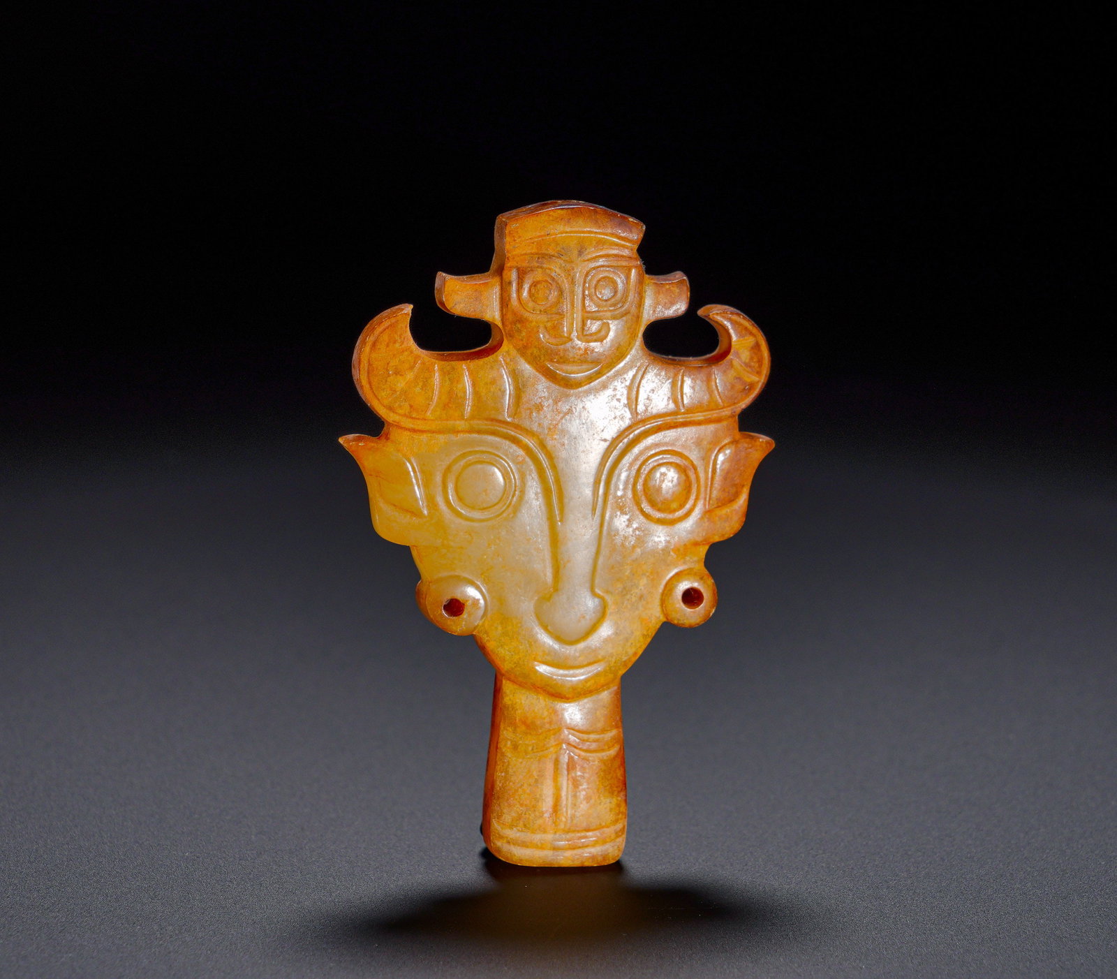 Shang Dynasty Divine figure Ox Head Composite jade pendant: Height:6.8cm(2.68in), Width:4.3cm(1.69in), Weight:40g (0.088lb)Archaic Jade Pendant with Superimposed Deity and Beast MaskThe jade is suffused with warm yellow penetrating patina and covered in