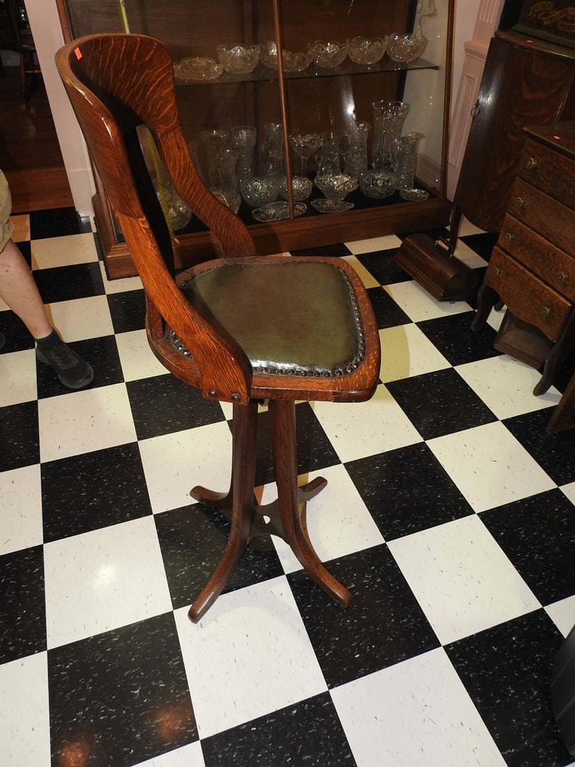 Sturgis-Style Antique Operator Posture Chair: Tall antique wooden operator/posture chair with curved arms, shaped back, leather or upholstered seat, and raised operator-style form. Approx. 48 x 19.5 x 19 in. Shows finish wear, upholstery wear,