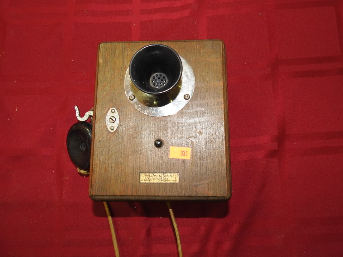 Antique Oak Desk Telephone: Antique oak desk/wall telephone unit with transmitter, receiver, cord, and wood case. Label is present but not fully legible in photos. Shows finish wear, scratches, metal patina, and age-related wear