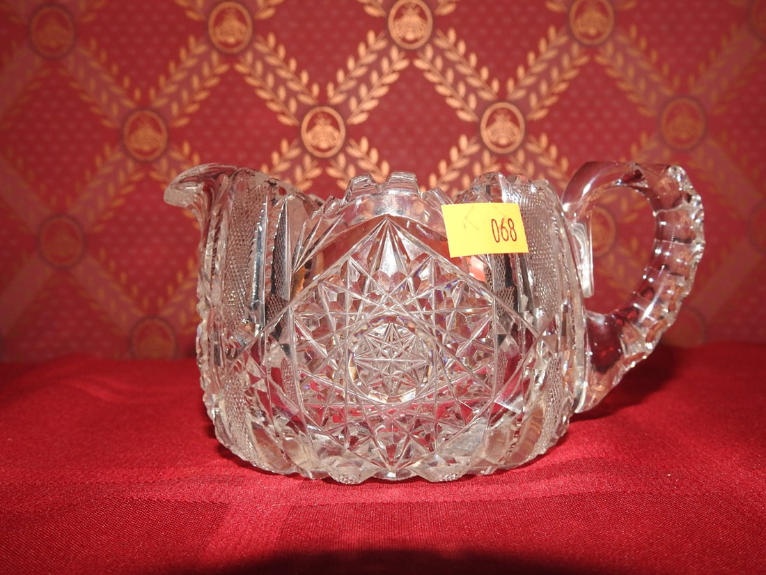 Cut Crystal Creamer: Vintage cut crystal creamer with applied handle, scalloped rim and geometric cut decoration. Approx. 2.5 x 3.5 x 5.5 in. Unmarked unless otherwise noted; maker/pattern attribution is based on visible