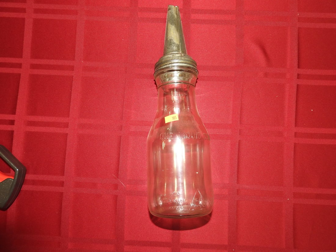 Antique Quart Glass Oil Bottle with Kaster Nozzle: Antique 1-quart glass oil bottle with metal Kaster-style nozzle/spout per notes. Approx. 13.5 x 3.75 x 3.75 in. Empty/decorative collectible; not tested for use. Shows age-related wear, patina,