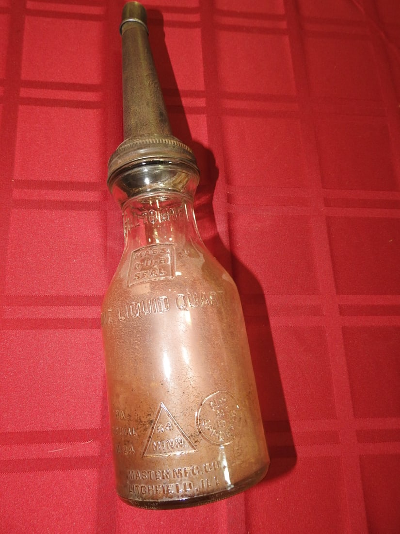 Unlabeled Quart Glass Oil Bottle, Made in MN: Antique unlabeled 1-quart glass oil bottle or automobile oil cannister marked Made in MN per notes. Approx. 15 x 4 x 4 in. No direct lot photos were included in the provided archives.
