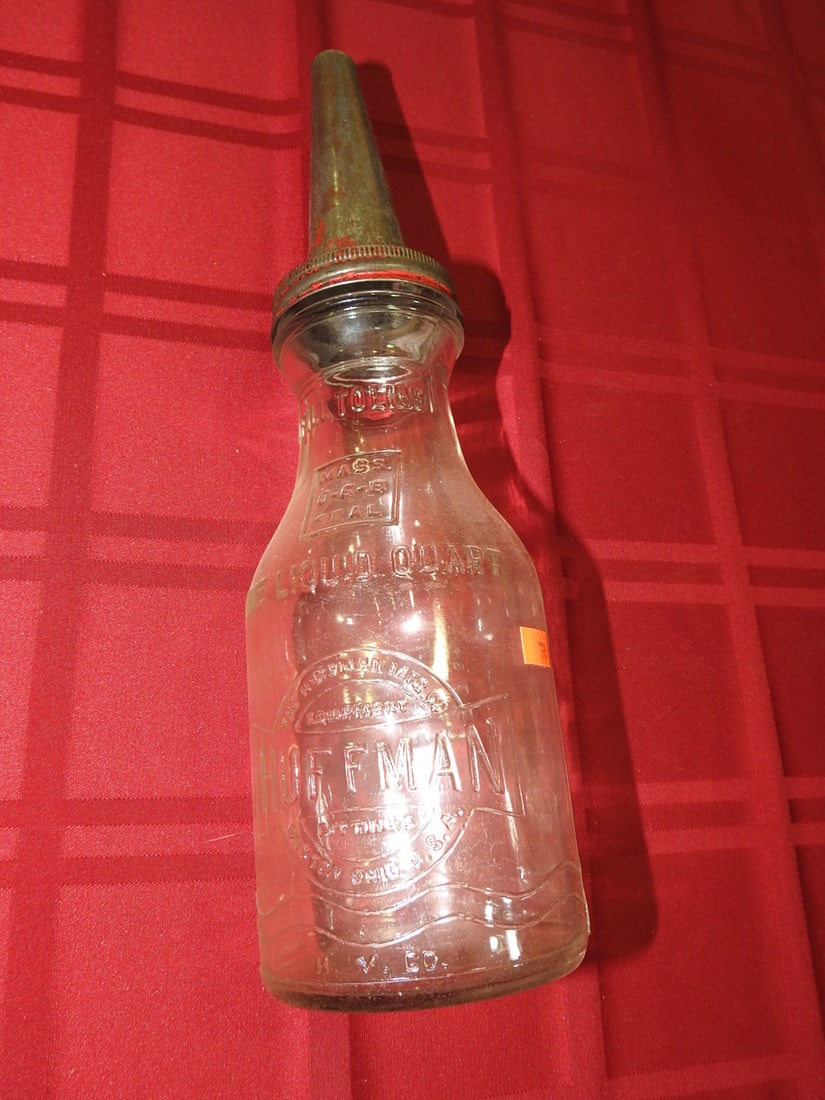 Hoffman Dayton Quart Glass Oil Bottle: Antique quart glass oil bottle marked Hoffman, Dayton, Ohio per notes. Approx. 13.75 x 3.75 x 3.75 in. Empty/decorative collectible; not tested for use. Shows age-related wear, patina, finish wear, ox