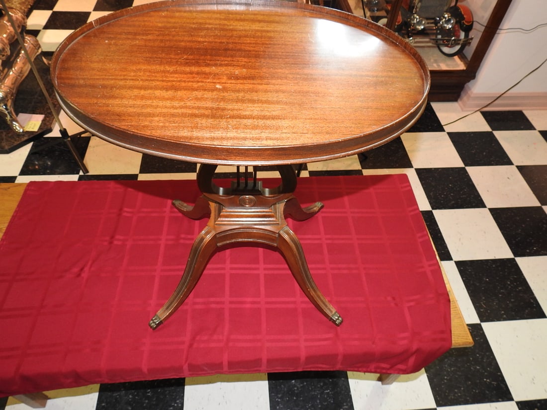 Turn-of-Century Round Wood Side Table: Antique round wooden side table, probably turn of the century, with pedestal base and carved/turned legs. Approx. 25.5 x 24.5 x 17 in. No maker mark noted. Shows finish wear, scratches, scuffs,