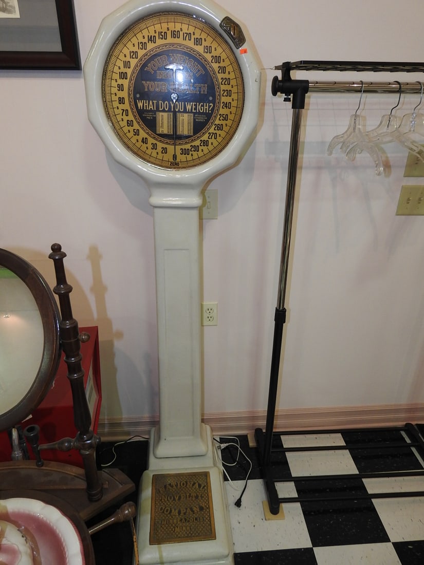 National Scale Co. White and Gold Physician Scale: Vintage National Scale Co. standing physician/platform scale with white enamel/porcelain-style body, gold-toned dial, and “What Do You Weigh?” weight chart graphics. Approx. 72 x 14 x 26 in. D