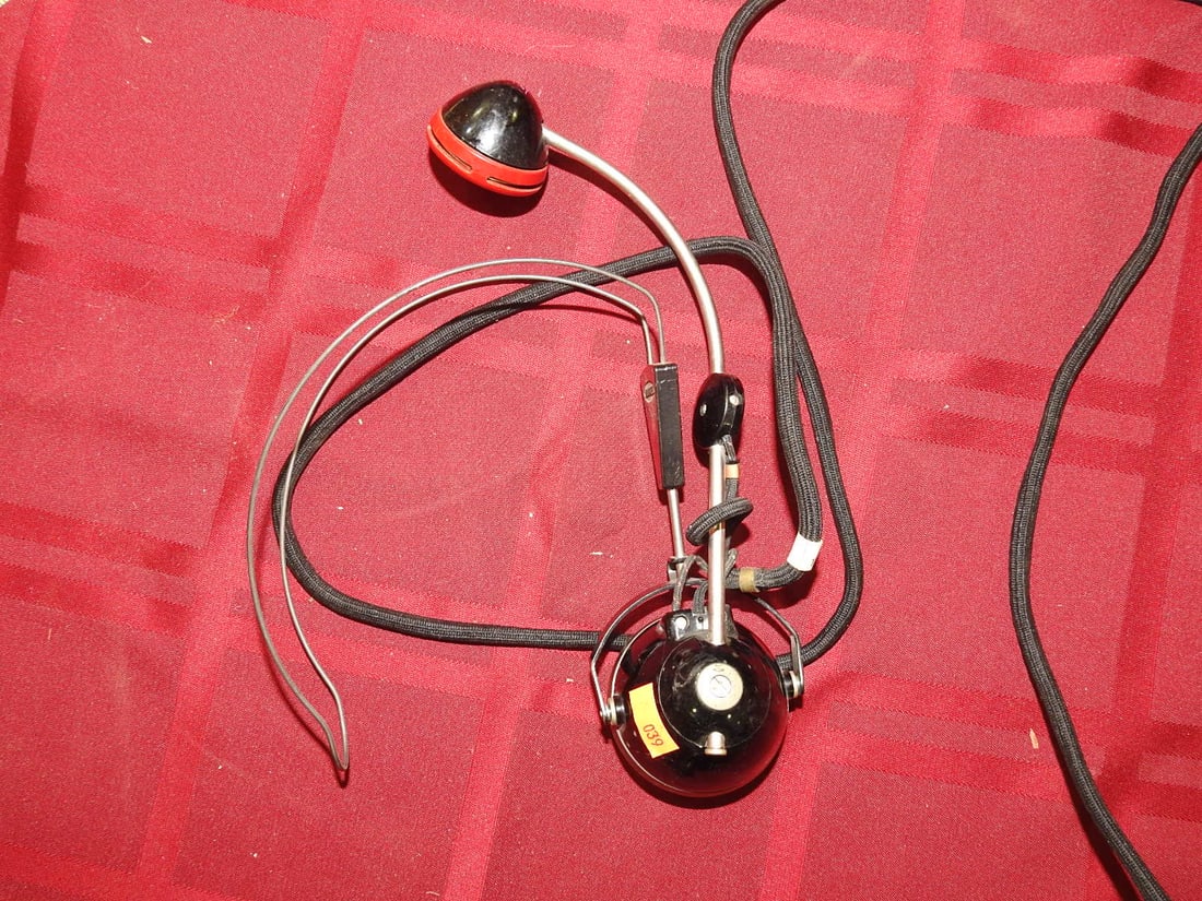 Early Telephone Operator Headset and Cord Parts: Assorted early telephone/operator headset or receiver parts with earpiece, cord, plug ends, and connector hardware. Maker not clearly visible. Shows oxidation, cord wear, tarnish, and age-related