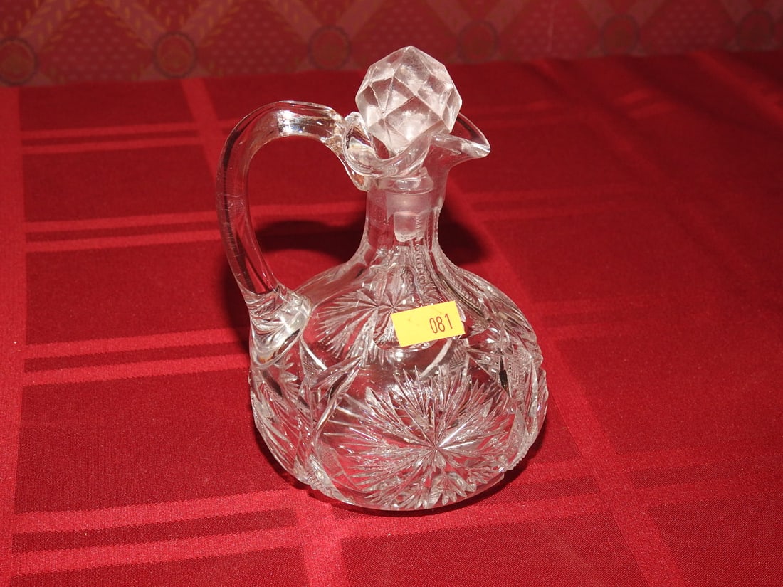 Cut Crystal Cruet with Stopper: Vintage cut crystal cruet with stopper, applied handle and star-cut base. Approx. 5.5 x 4 x 4 in. Unmarked unless otherwise noted; maker/pattern attribution is based on visible form, cuts and common