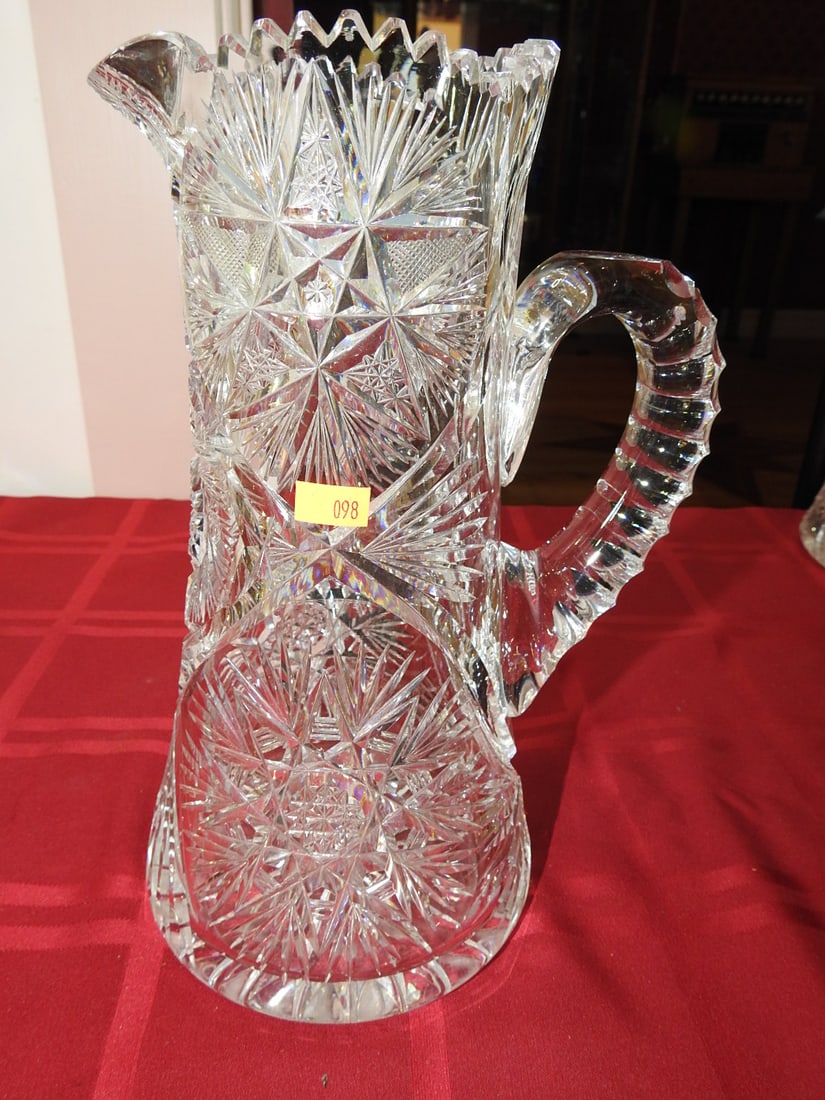ABP Cut Glass Water Pitcher: American Brilliant Period hand-cut glass water pitcher with applied handle and geometric/hobstar cut decoration. Approx. 11 x 4 x 7.5 in. Unmarked unless otherwise noted; maker/pattern attribution is