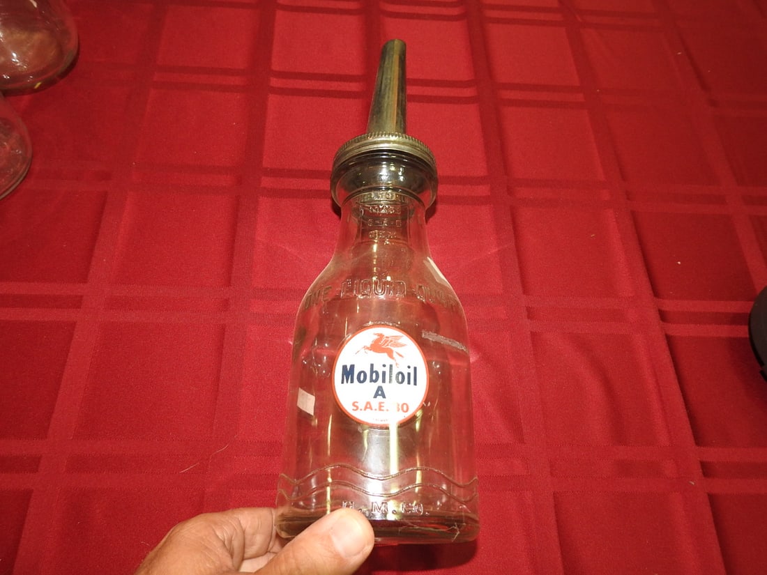 Mobiloil Glass Oil Bottle with Spout: Antique quart glass oil bottle with Mobiloil label and metal spout. Approx. 13.5 x 3.75 x 3.75 in. Empty/decorative collectible; not tested for use. Shows age-related wear, patina, finish wear,