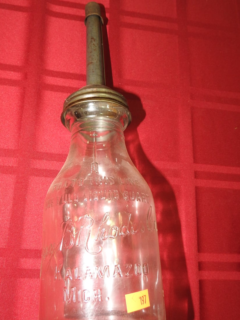 Jay B. Rhodes Co. Quart Glass Oil Bottle: Antique quart glass oil bottle marked Jay B. Rhodes Co., Kalamazoo, Michigan per notes. Approx. 14 x 4 x 4 in. Empty/decorative collectible; not tested for use. Shows age-related wear, patina, finish